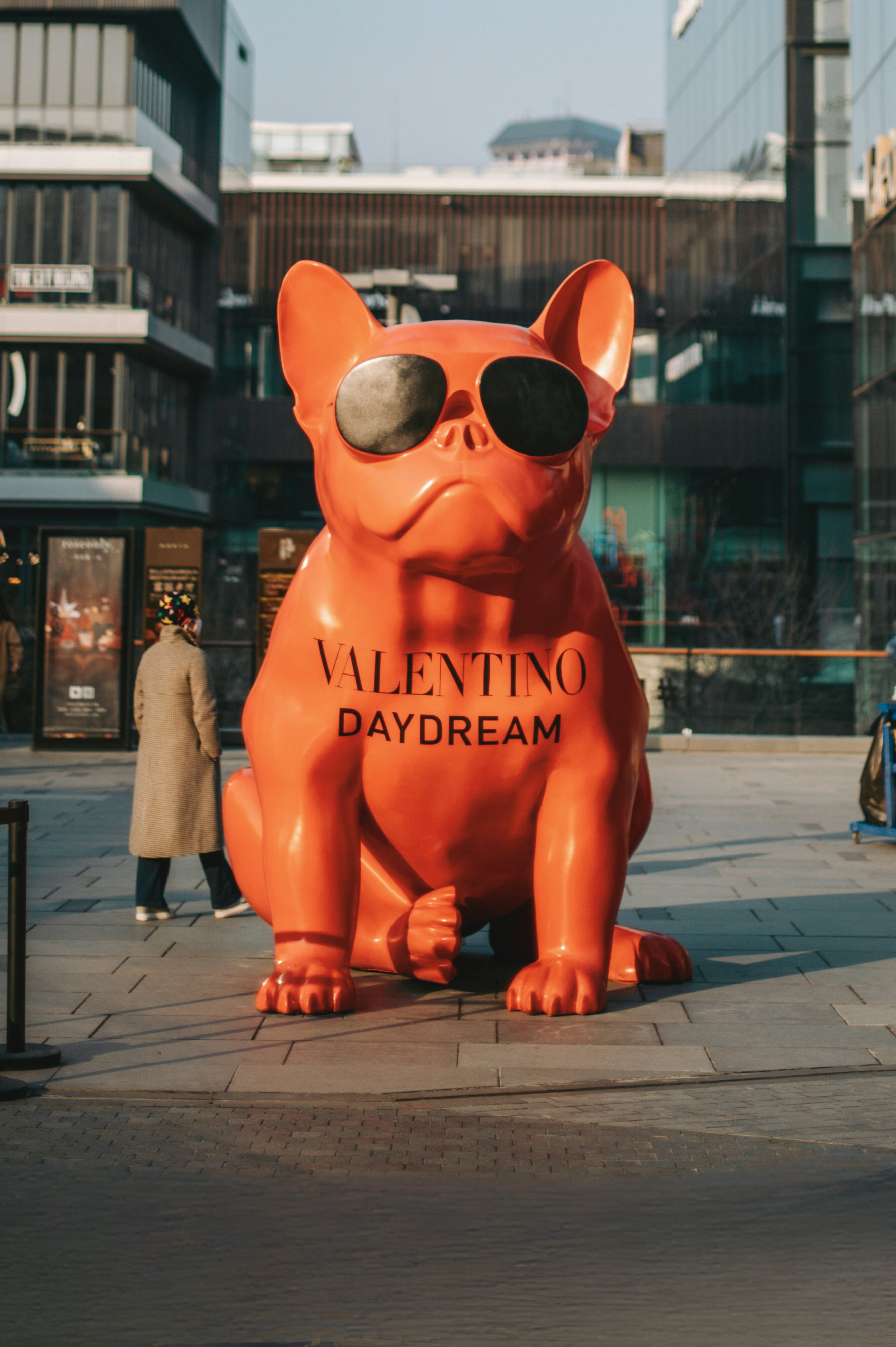 Sunglasses-wearing pink sculpture with 'Valentino Daydream' text, symbolizing creative and impactful branding.